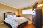 Bedroom has comfortable queen size bed with memory foam mattress and TV